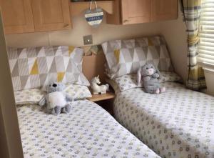 インゴールドメルズにあるDisabledAccess Beautiful 6 Berth Millfieldsのツインベッド2台(詰め物の座った動物付)