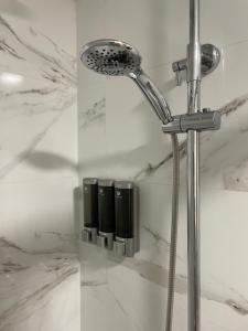 een douchekop in een badkamer met wit marmer bij Apartamento Granadella in Platja de l'Arenal