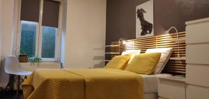 a bedroom with a bed with a yellow bedspread at Appartement de charme 1860-1900 in Colmar +13 photos