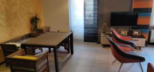 a room with a table and chairs and a television at Appartement de charme 1860-1900 in Colmar