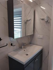 a white bathroom with a sink and a mirror at Orkide Sapanca in Sapanca