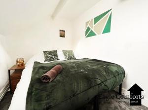 a bedroom with a bed with a green comforter at 5 Bedroom House-20 percent off monthly stays in Neepsend