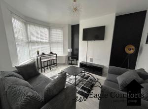 a living room with a couch and a table at 5 Bedroom House-20 percent off monthly stays in Neepsend