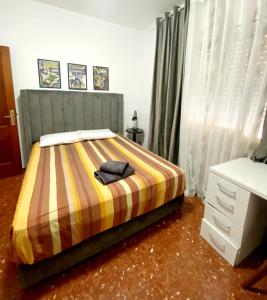 a bedroom with a bed with a striped comforter at Genial casa en centro in Ceuta