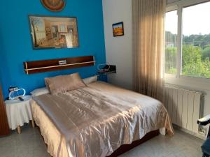a bedroom with a bed and a blue wall at Villa Maria Mercedes in Olesa de Bonesvalls +20 photos
