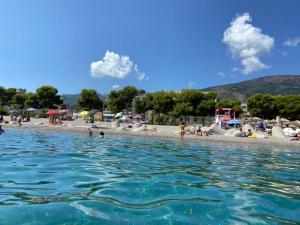 a group of people in the water at a beach at La casa sul mare in Patti