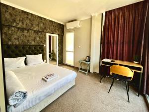 a hotel room with a bed and a desk at Damyanov House in Kazanlŭk