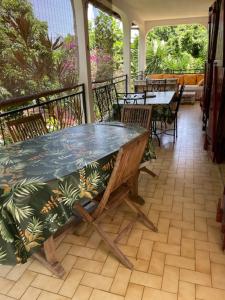 a patio with a table and chairs on a porch at La Canopée Enchantée, chambres d'hôtes, piscine, proche aéroport, Gare maritime in Les Abymes