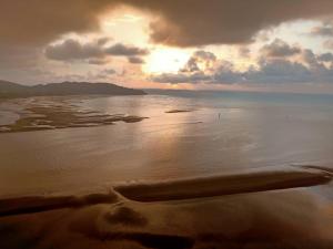 a view of a beach with the sun setting on the water at Imperium Residence House SEAVIEW at Swiss Belhotel in Kuantan