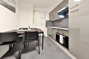ミュルーズにあるModerne et spacieux, près du centre de Mulhouseの部屋にテーブルと椅子のあるキッチン