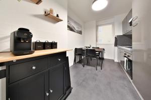 ミュルーズにあるModerne et spacieux, près du centre de Mulhouseのキッチン(黒いキャビネット、テーブル、椅子付) +19枚の写真