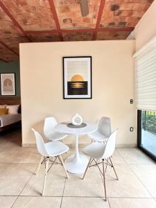 a dining room with a table and white chairs at Serene Oasis Studio - Outdoor Salt Water Pool in Ajijic