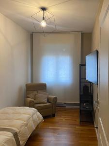 a bedroom with a bed and a chair and a flat screen tv at Giotto 2 Guesthouse in Maserà di Padova +15 photos