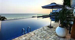 a swimming pool with an umbrella next to the ocean at Departamento en Manta Edificio Poseidon in Manta