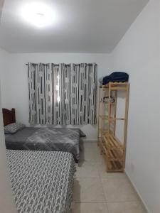 a room with two beds and a book shelf at Casa central in Serra Negra +13 photos