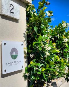 een bord aan de zijkant van een gebouw met bloemen bij Casa Fralia in Olbia