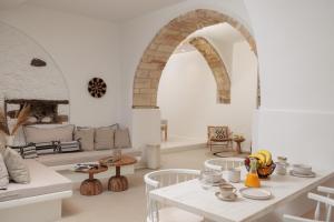 a white living room with a table and chairs at Casa di Grazia in Naxos Chora
