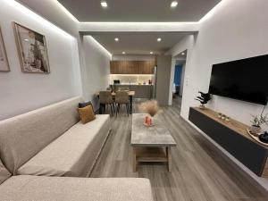 a living room with a couch and a flat screen tv at The Heidi's Central House in Kos Town