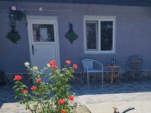 a blue house with a table and chairs and flowers at The Purple House-Villa in Bucharest in Bucharest