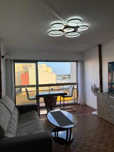 a living room with a couch and a table at Loft en plein centre, Vue port in Cap d'Agde +5 photos