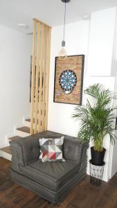 a couch in a living room with a clock on the wall at Et Pop Et Chic, la maison ! in Poitiers