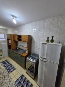 a kitchen with a refrigerator and a stove at Apto no Centro de São Leopoldo in São Leopoldo