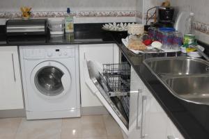 una cocina con lavadora y fregadero en Malabata Duplex, en El Balia