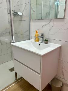 a bathroom with a white sink and a shower at Apartman Ante Škoda Pivica in Povljana