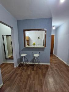 a room with a counter and two stools and a mirror at Apto no Centro de São Leopoldo in São Leopoldo