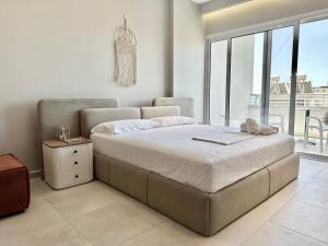 a bedroom with a large bed and a large window at O'Det Luxury Rooms & Apartments in Sarandë