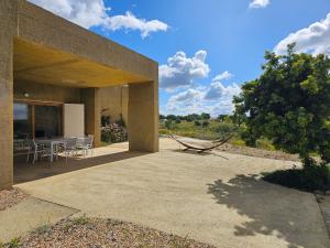 ein Haus mit einer Hängematte auf einer Terrasse in der Unterkunft Casa de Mosqueirões in Santa Margarida da Serra