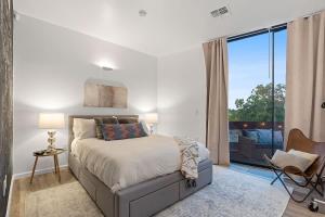 a bedroom with a bed and a large window at 2BR Designer Condo on Trendy East 11th St, Downtown Austin in Austin