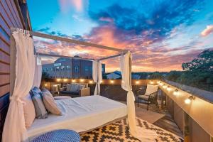 a bed on a balcony with a sunset in the background at 2BR Designer Condo on Trendy East 11th St, Downtown Austin in Austin +33 photos