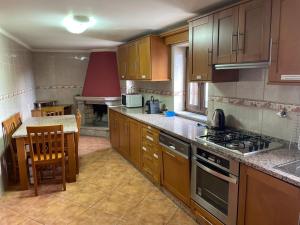 a kitchen with wooden cabinets and a stove top oven at Casa Dina Doceira in Geres