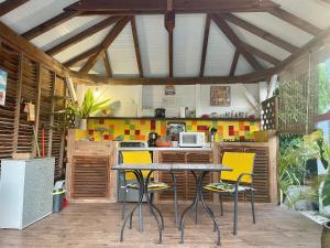 cocina con mesa y sillas amarillas en Sarithea, en Basse-Terre