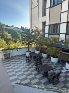 a patio with benches and tables in front of a building at Nova 家庭房 in Brinchang
