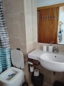 a bathroom with a white sink and a toilet at 89 Steps Symi in Symi