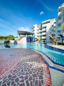 a swimming pool with giraffes and a building at Homelite Resort in Miri +6 photos