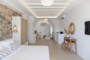 a white bedroom with a bed and a table and a desk at Casa di Grazia in Naxos Chora