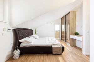 a bedroom with a bed with a black headboard at Novalja Centar Retreat in Novalja
