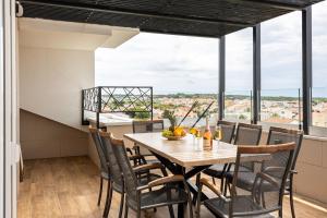 a dining room with a table and chairs and large windows at Novalja Centar Retreat in Novalja