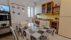 cocina con mesa de comedor y TV en Villa Rita - Casa Vista Mare - Vasto Punta Penna, en Vasto