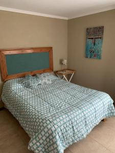 a bedroom with a bed with a blue and white comforter at Dormis Llao in San Carlos de Bariloche