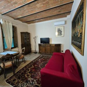 a living room with a red couch and a table at La Rosa Rossa in San Casciano dei Bagni