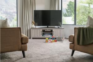 uma sala de estar com uma televisão de ecrã plano e 2 cadeiras em Redfern Retreat em Queenstown mais 44 fotografias