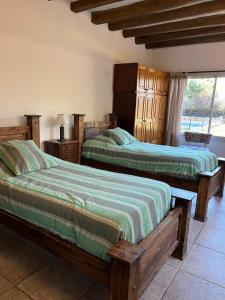 a bedroom with two beds and a window at La casita en el parque in Chacras de Coria