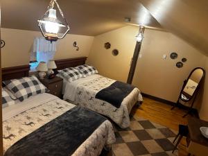 a bedroom with two beds and a mirror and a lamp at Chez Odette, suite international in Roberval