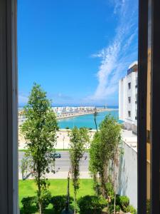 a view of the ocean from a window of a building at Appartement front de mer Tanger in Tangier