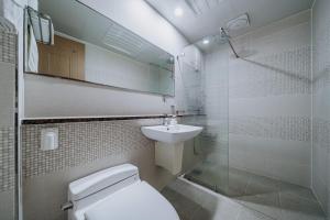 a bathroom with a toilet and a sink and a shower at Nohyung Hotel in Jeju