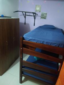 un letto con lenzuola blu e un armadietto in legno di Casa acogedora Girardot 150mts a Girardot